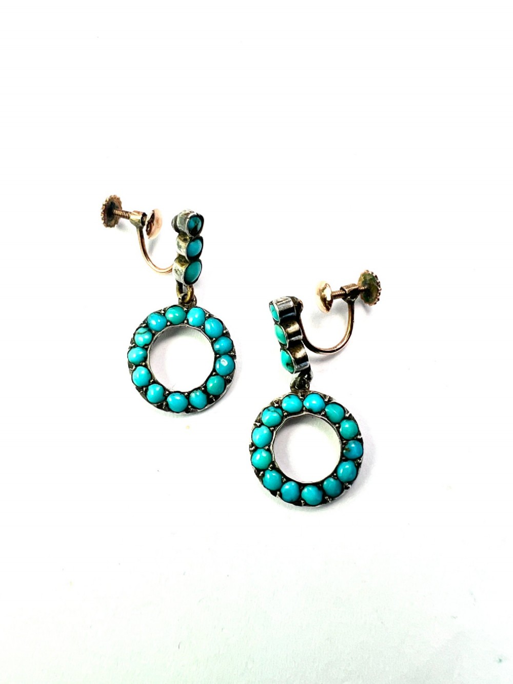 A pair of Victorian gold and silver drop earrings featuring circular open-hoop motifs set with small turquoise cabochons. View IV