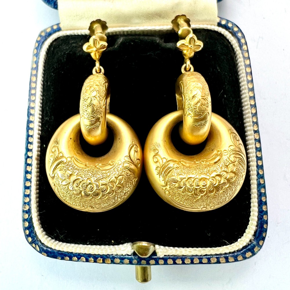 A pair of Victorian 15ct yellow gold drop earrings featuring floral engraving and interlocking circular hoops.