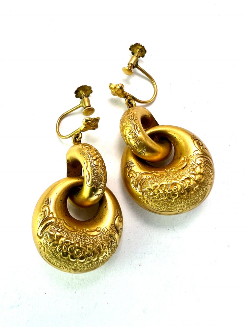 A pair of Victorian 15ct yellow gold drop earrings featuring floral engraving and interlocking circular hoops. View IV