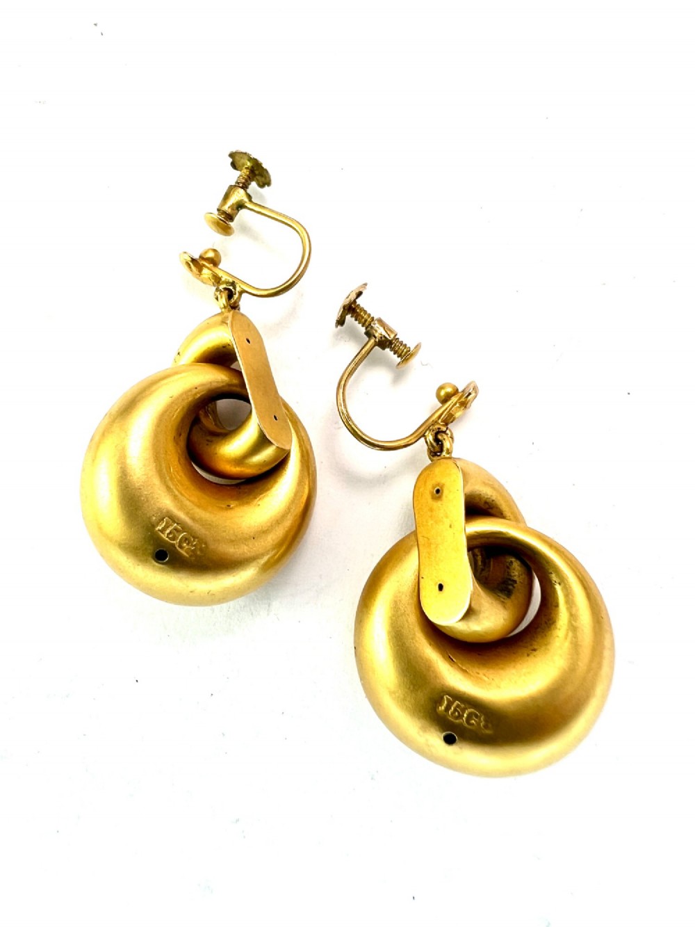 A pair of Victorian 15ct yellow gold drop earrings featuring floral engraving and interlocking circular hoops. View V