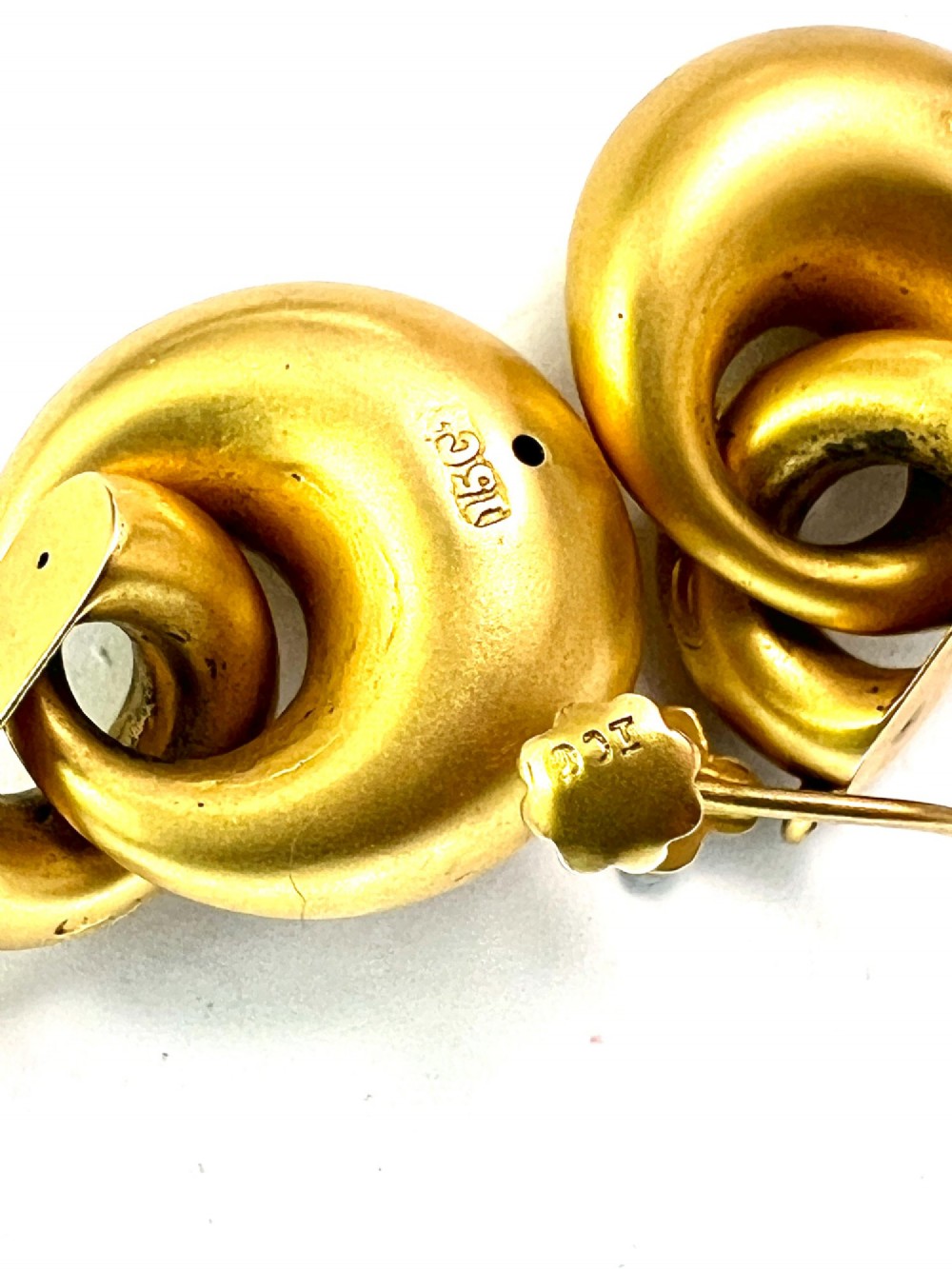 A pair of Victorian 15ct yellow gold drop earrings featuring floral engraving and interlocking circular hoops. View VI