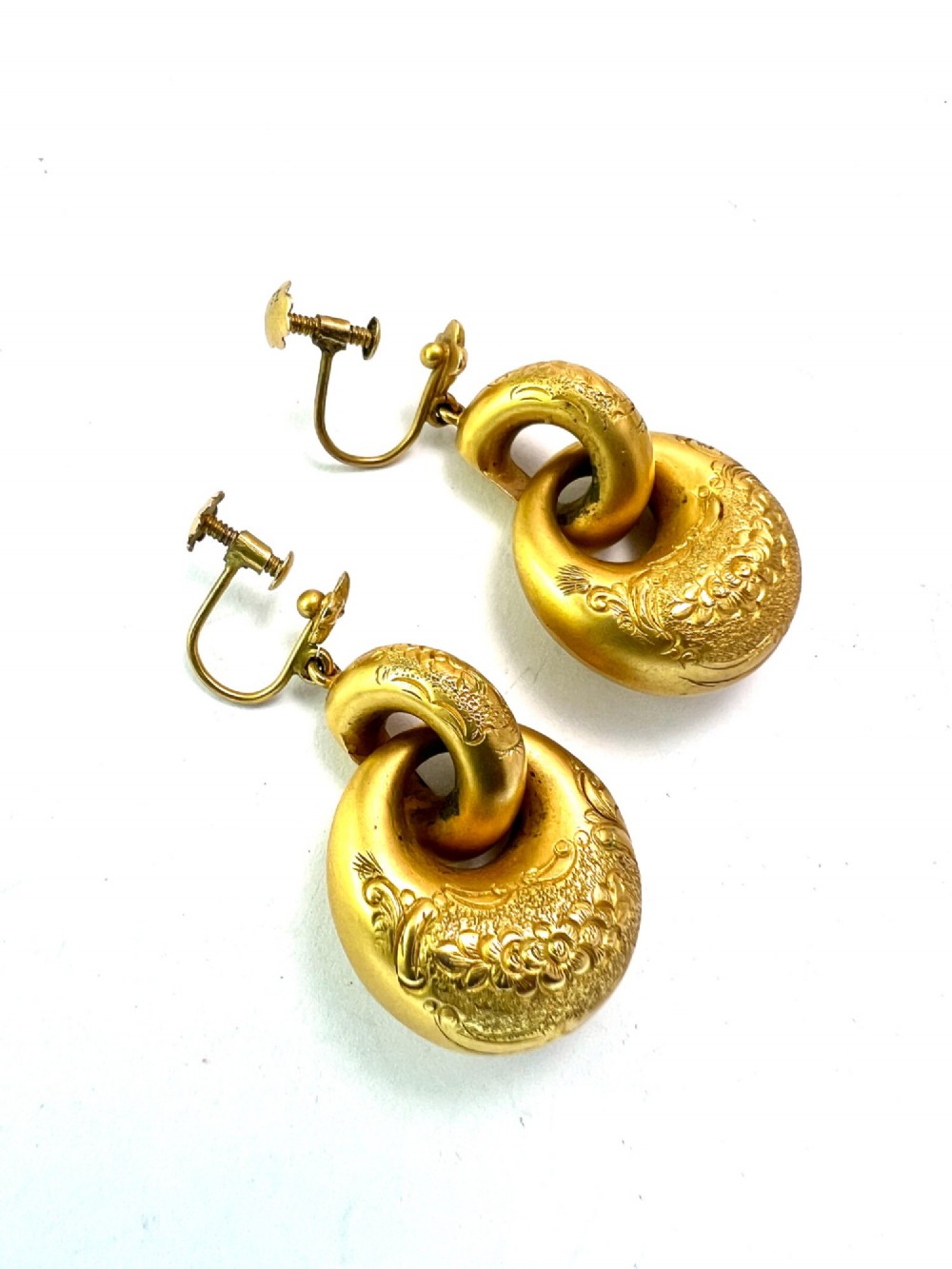 A pair of Victorian 15ct yellow gold drop earrings featuring floral engraving and interlocking circular hoops. View VII