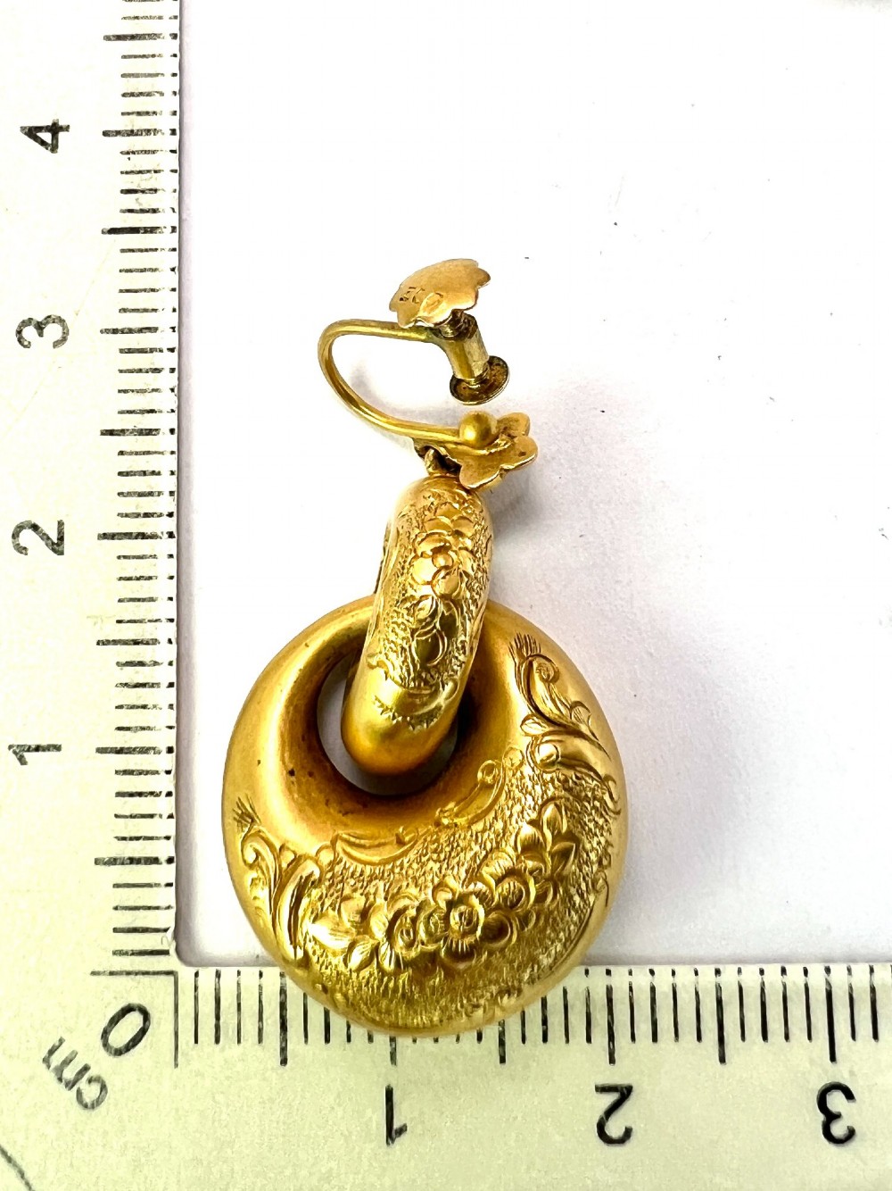 A pair of Victorian 15ct yellow gold drop earrings featuring floral engraving and interlocking circular hoops. View VIII