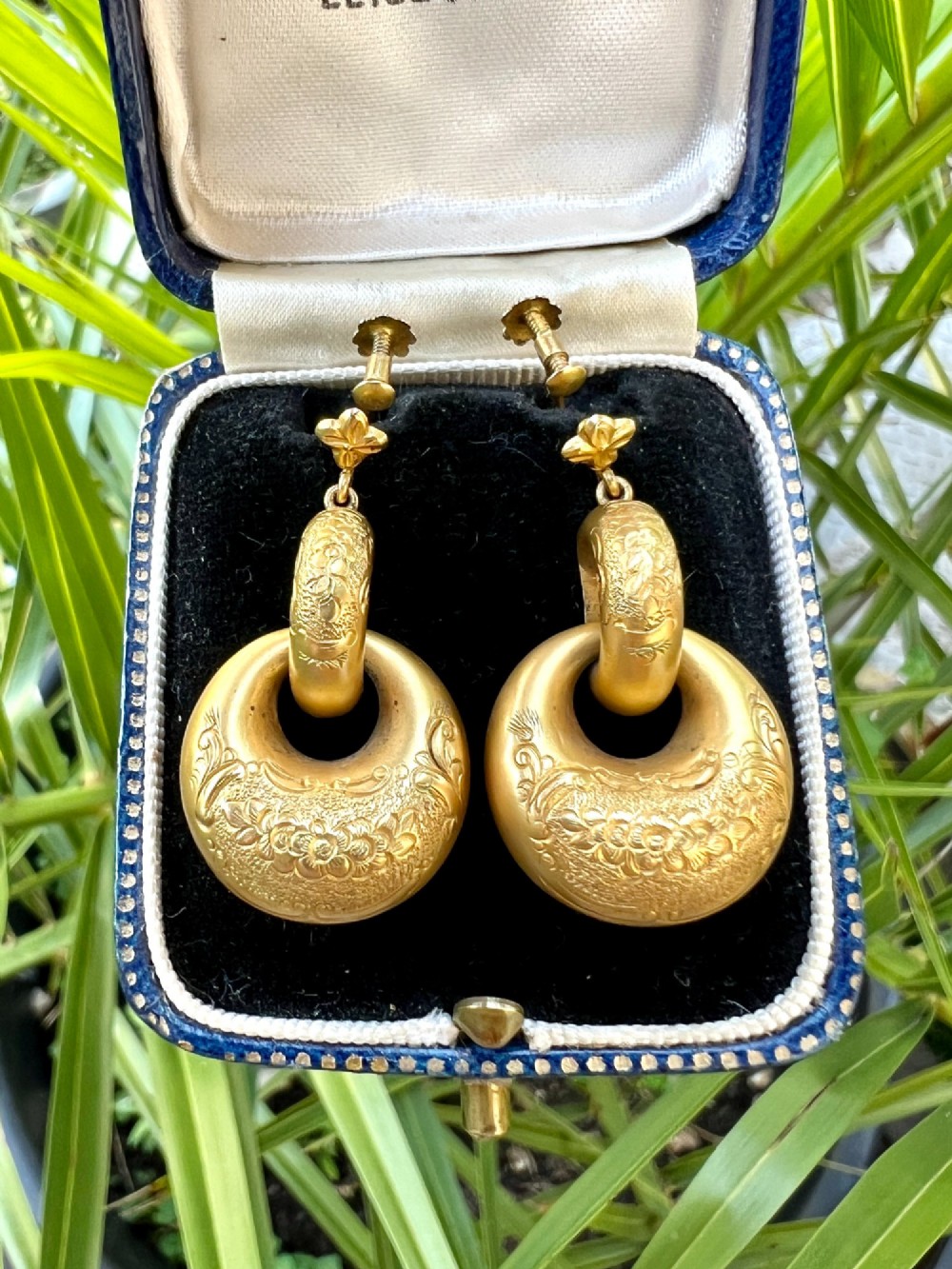 A pair of Victorian 15ct yellow gold drop earrings featuring floral engraving and interlocking circular hoops. View IX