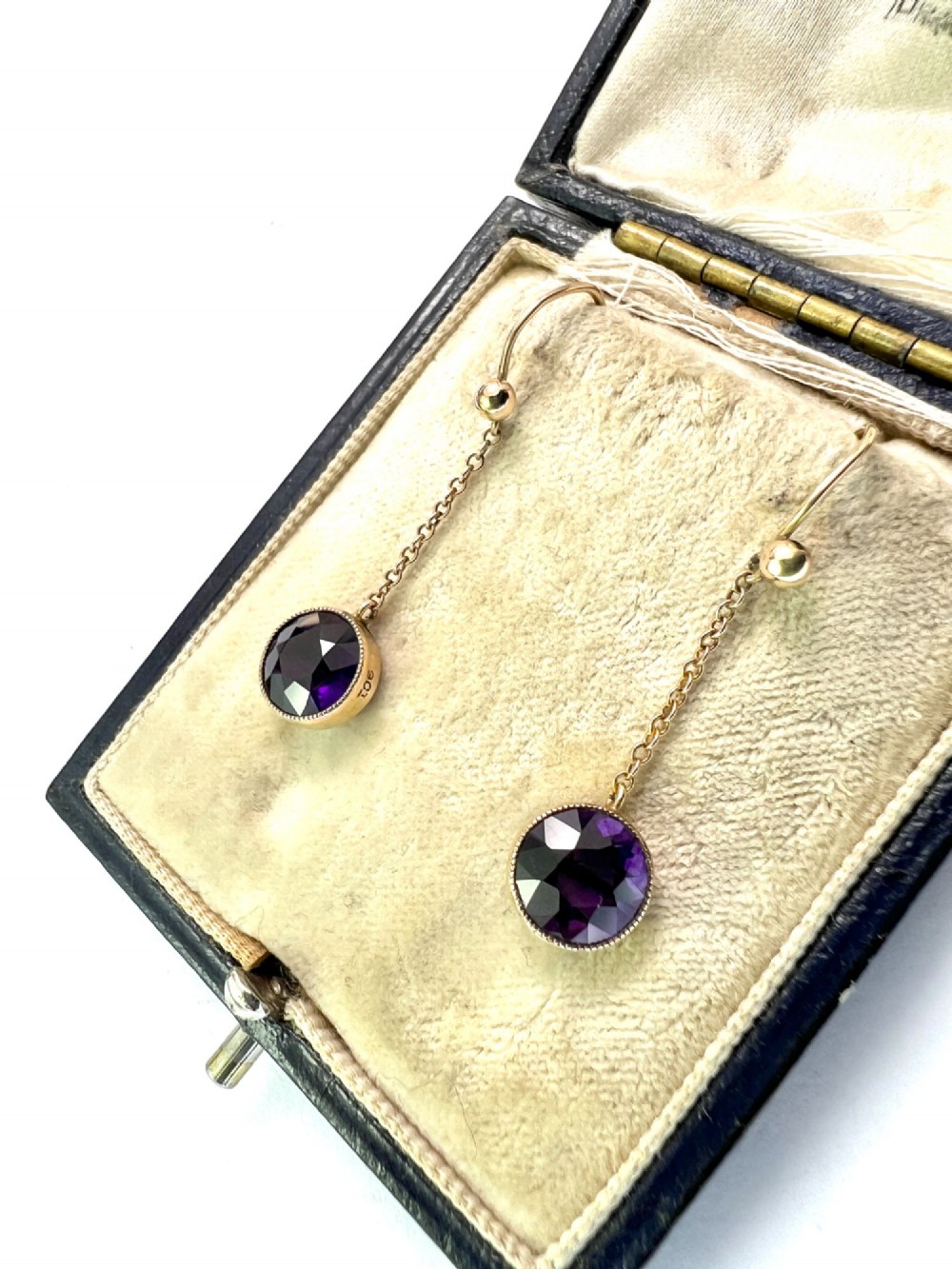 A pair of Edwardian 9ct yellow gold drop earrings featuring round, bezel-set faceted purple amethysts suspended from fine link chains. View III