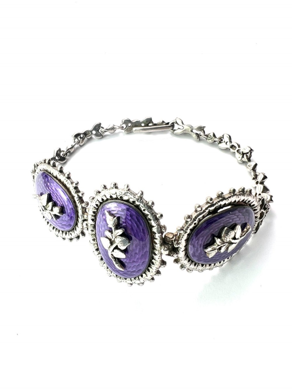 A matching silver jewellery set featuring purple guilloche enamel panels decorated with silver leaf motifs, including drop earrings, a ring, and an articulated link bracelet. View III