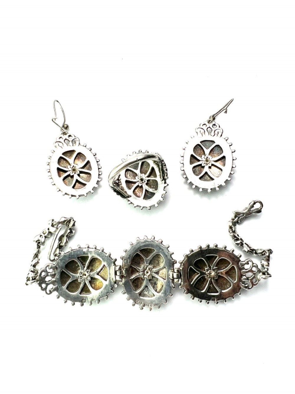 A matching silver jewellery set featuring purple guilloche enamel panels decorated with silver leaf motifs, including drop earrings, a ring, and an articulated link bracelet. View VII