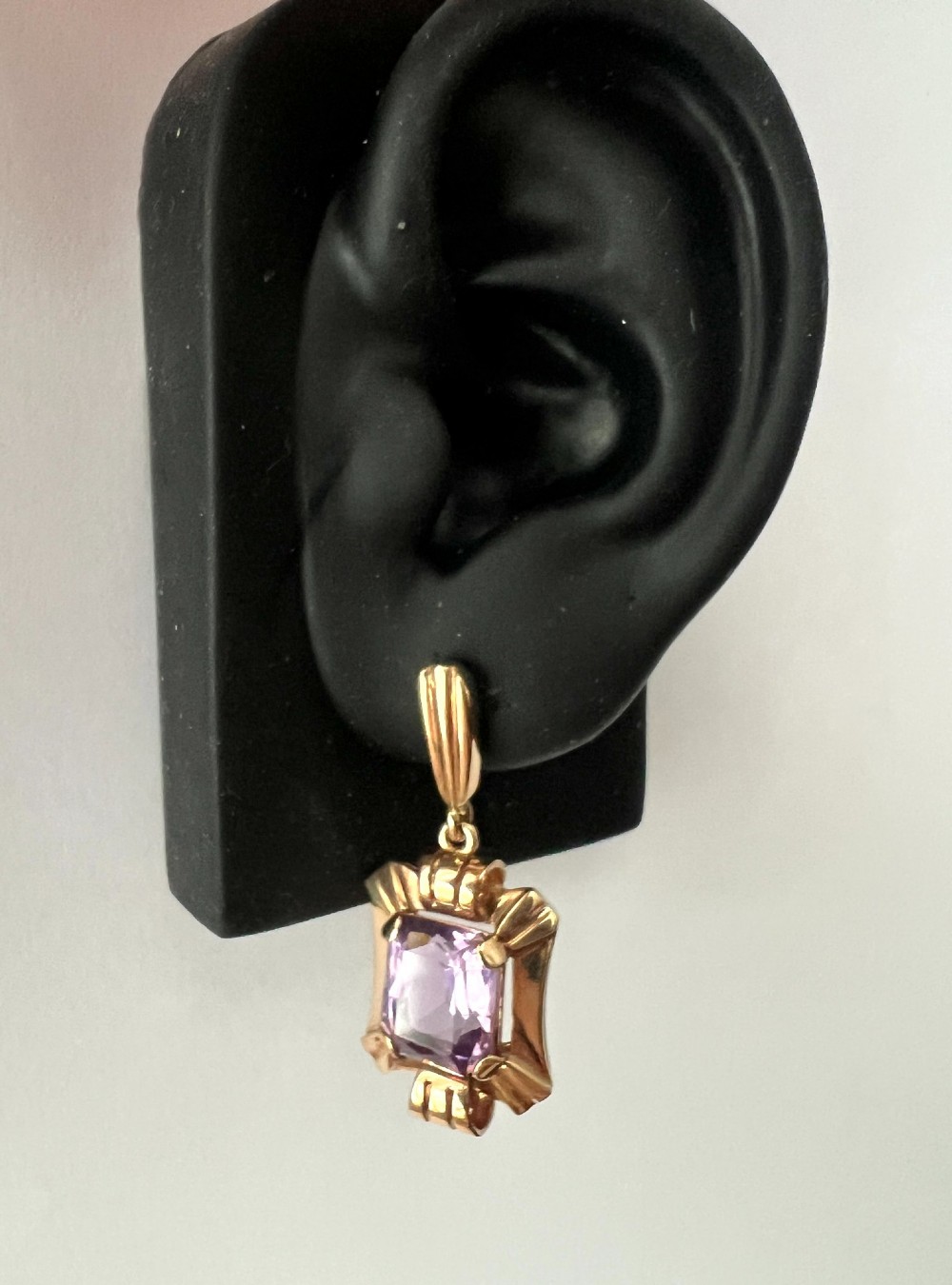 A pair of late Art Deco gold drop earrings featuring rectangular emerald-cut purple amethyst stones set within fluted geometric mounts. View VIII