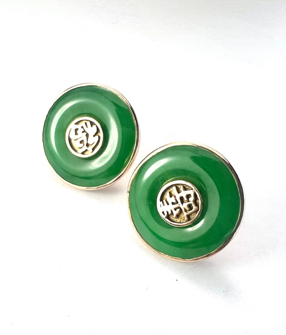 Pair of circular green jade torus stud earrings with central fourteen-carat gold character medallions.