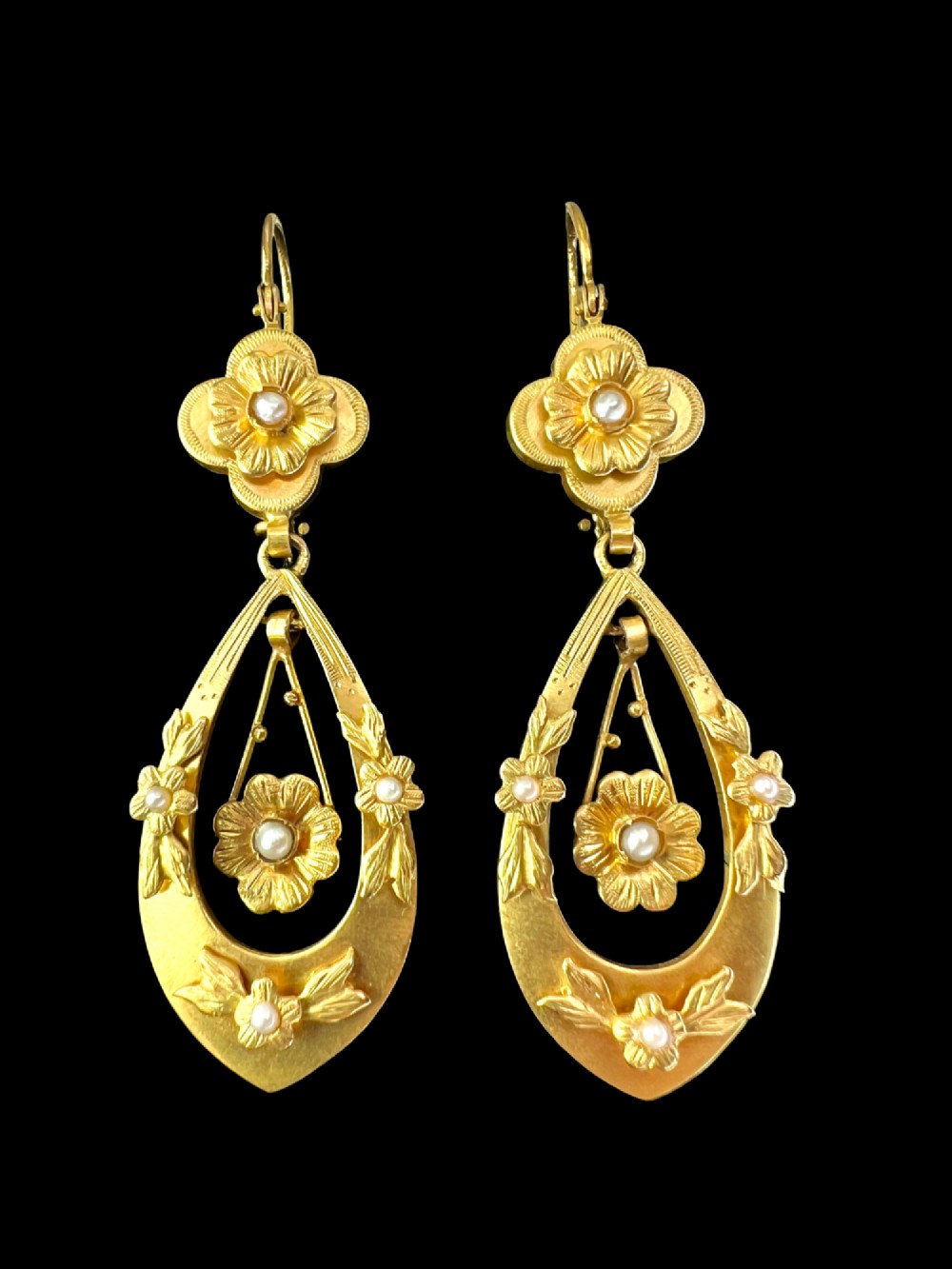 A pair of late Victorian yellow gold drop earrings featuring floral detailing and central pearl settings. View IV