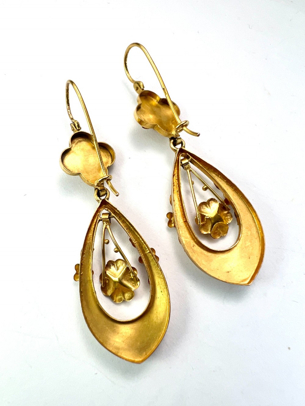 A pair of late Victorian yellow gold drop earrings featuring floral detailing and central pearl settings. View VI