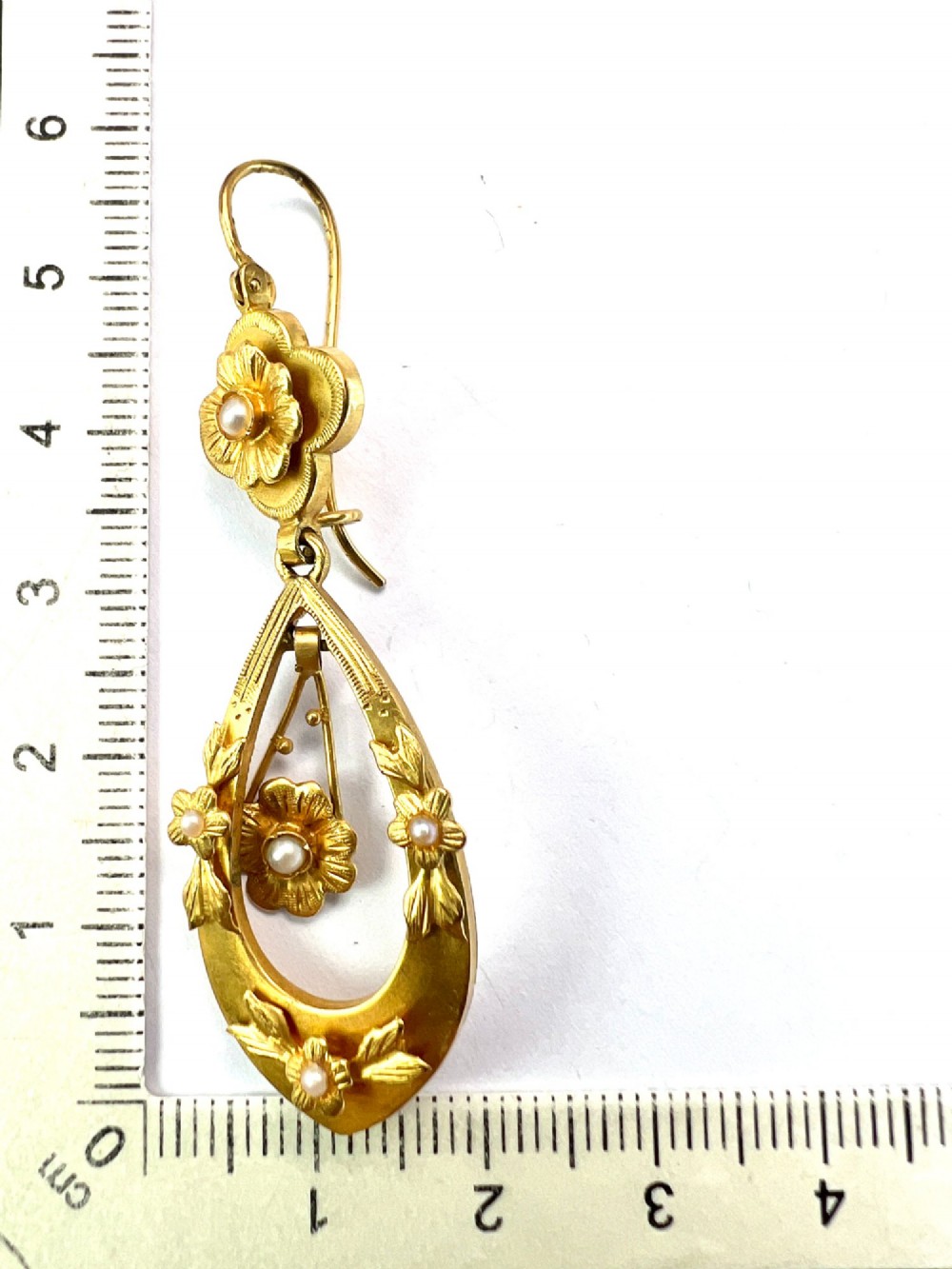 A pair of late Victorian yellow gold drop earrings featuring floral detailing and central pearl settings. View VII