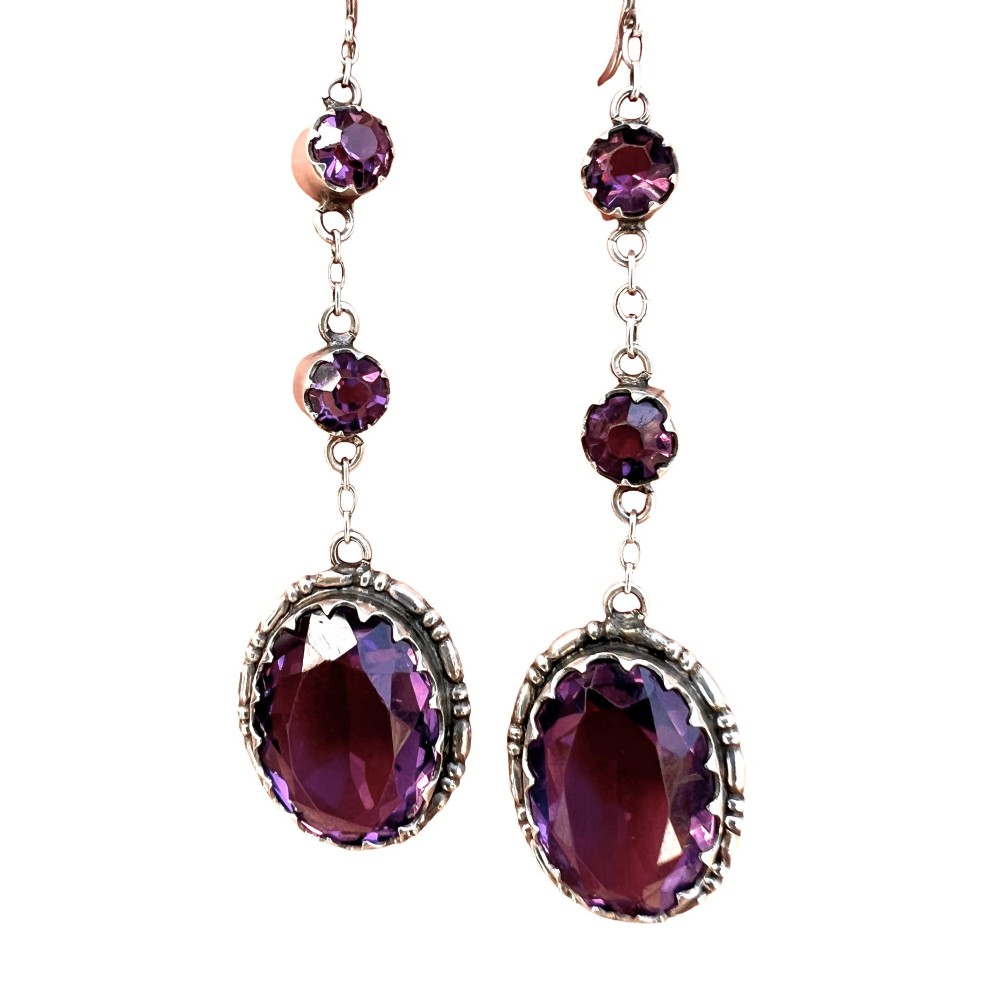 A pair of Art Deco drop earrings featuring faceted purple paste stones set in silver with screwback mechanisms. View III