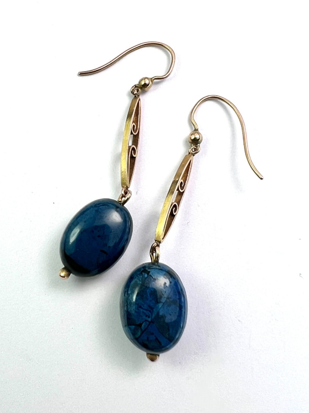 A pair of Edwardian yellow gold drop earrings featuring openwork scrollwork links suspended above oval blue apatite cabochon drops. View III