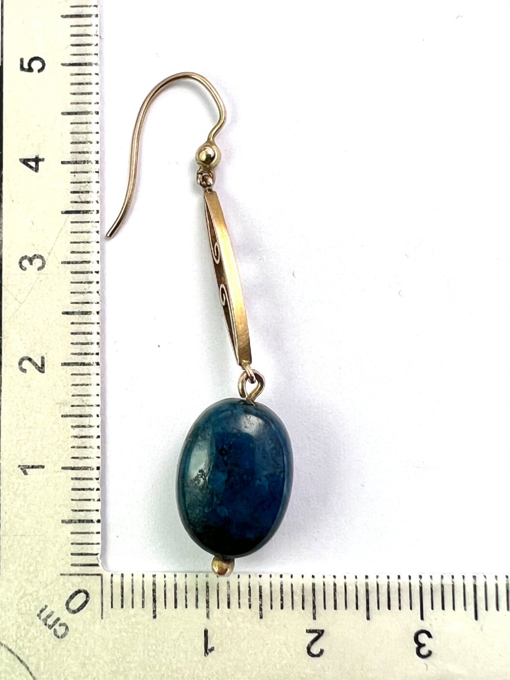 A pair of Edwardian yellow gold drop earrings featuring openwork scrollwork links suspended above oval blue apatite cabochon drops. View V