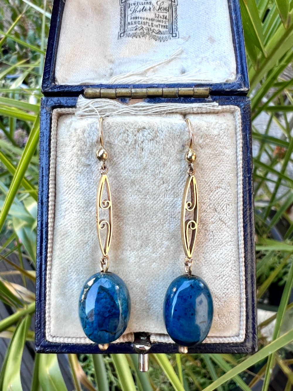A pair of Edwardian yellow gold drop earrings featuring openwork scrollwork links suspended above oval blue apatite cabochon drops. View VI