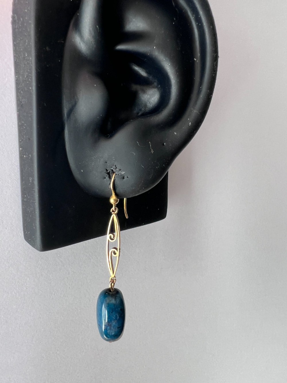A pair of Edwardian yellow gold drop earrings featuring openwork scrollwork links suspended above oval blue apatite cabochon drops. View VII