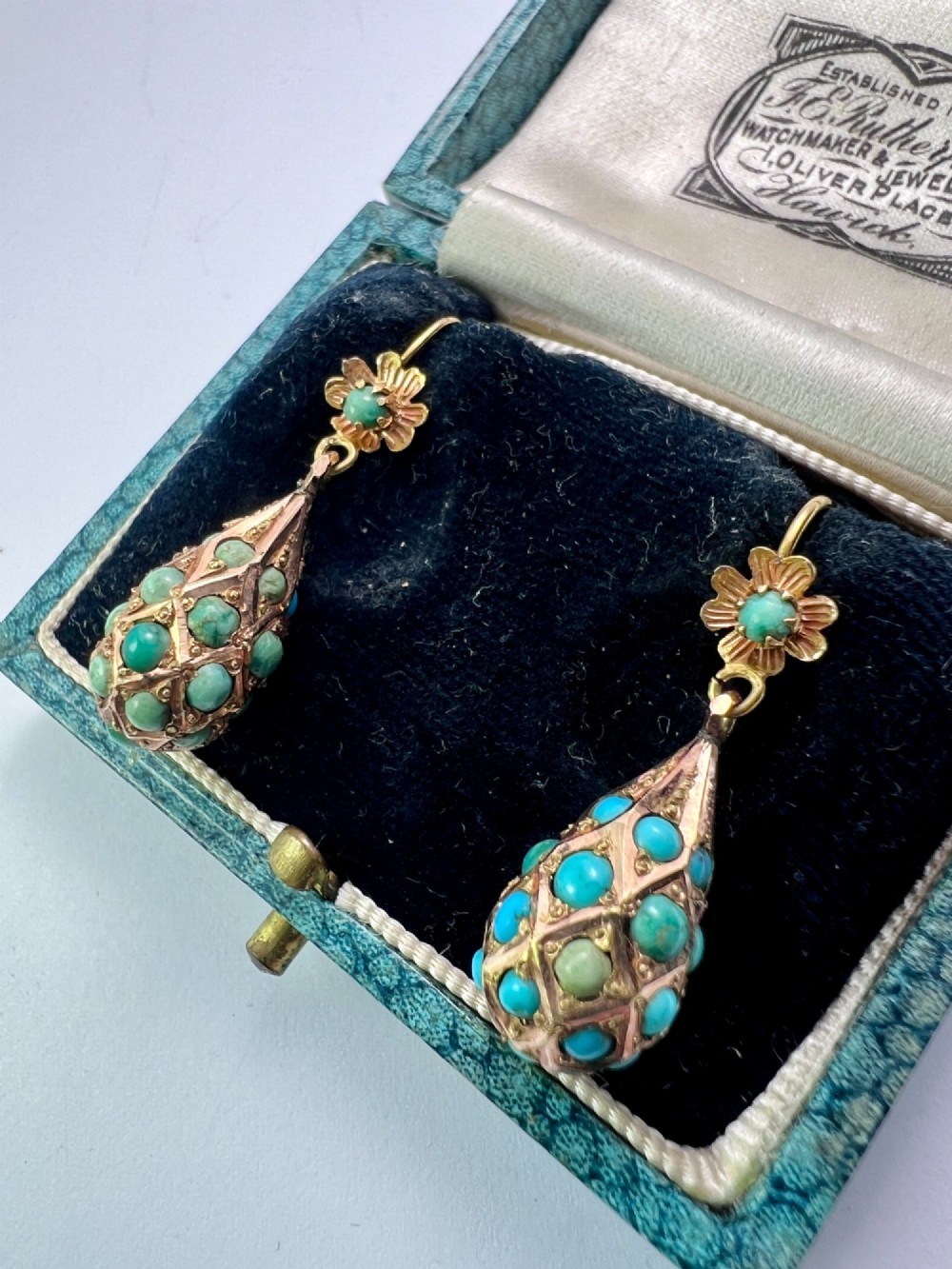 A pair of Victorian gold drop earrings featuring floral tops and lattice-engraved teardrop pendants set with turquoise cabochon stones. View III