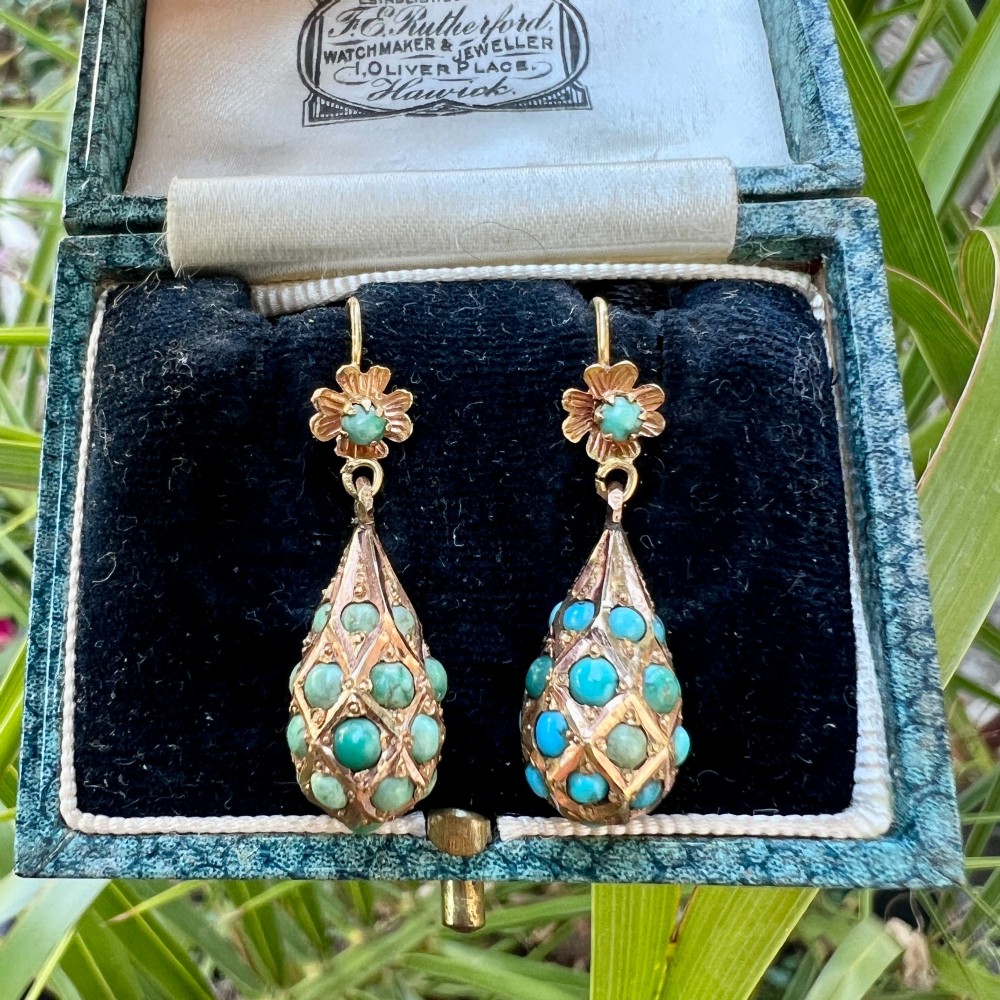 A pair of Victorian gold drop earrings featuring floral tops and lattice-engraved teardrop pendants set with turquoise cabochon stones. View VII