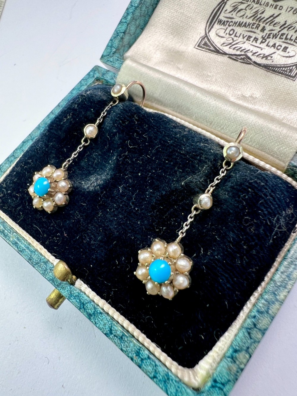 A pair of Edwardian gold drop earrings featuring floral cluster pendants set with central turquoise cabochons surrounded by pearls. View II