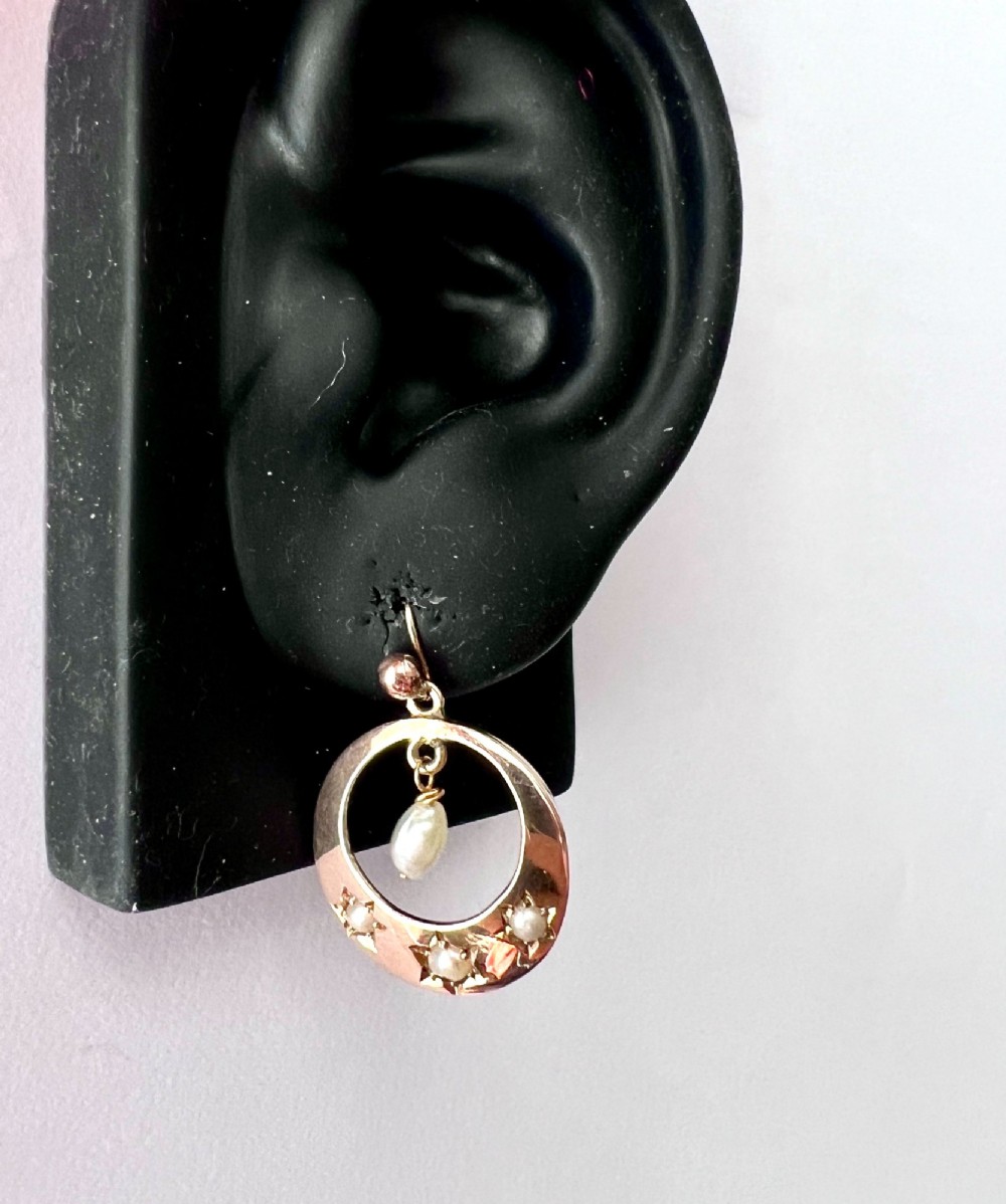 A pair of yellow gold Victorian crescent drop earrings featuring star-set seed pearls and a suspended central pearl drop. View VIII