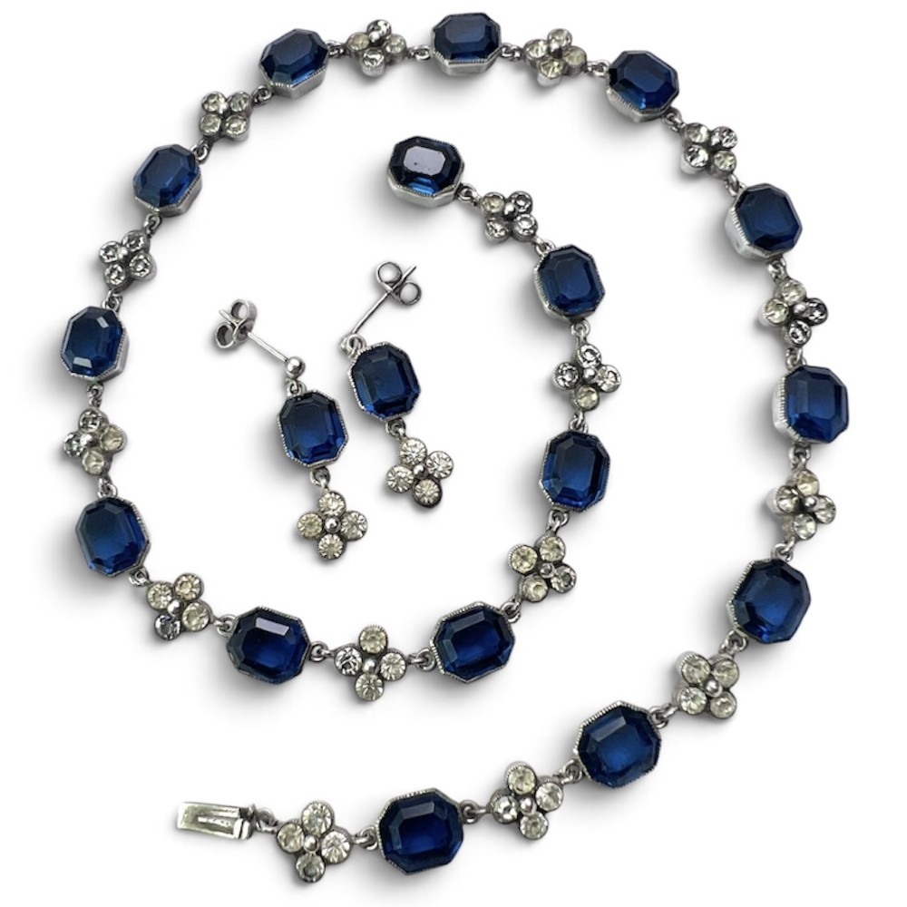 An Art Deco silver jewellery set comprising a link necklace and drop earrings with octagonal blue paste stones and clear cluster links.