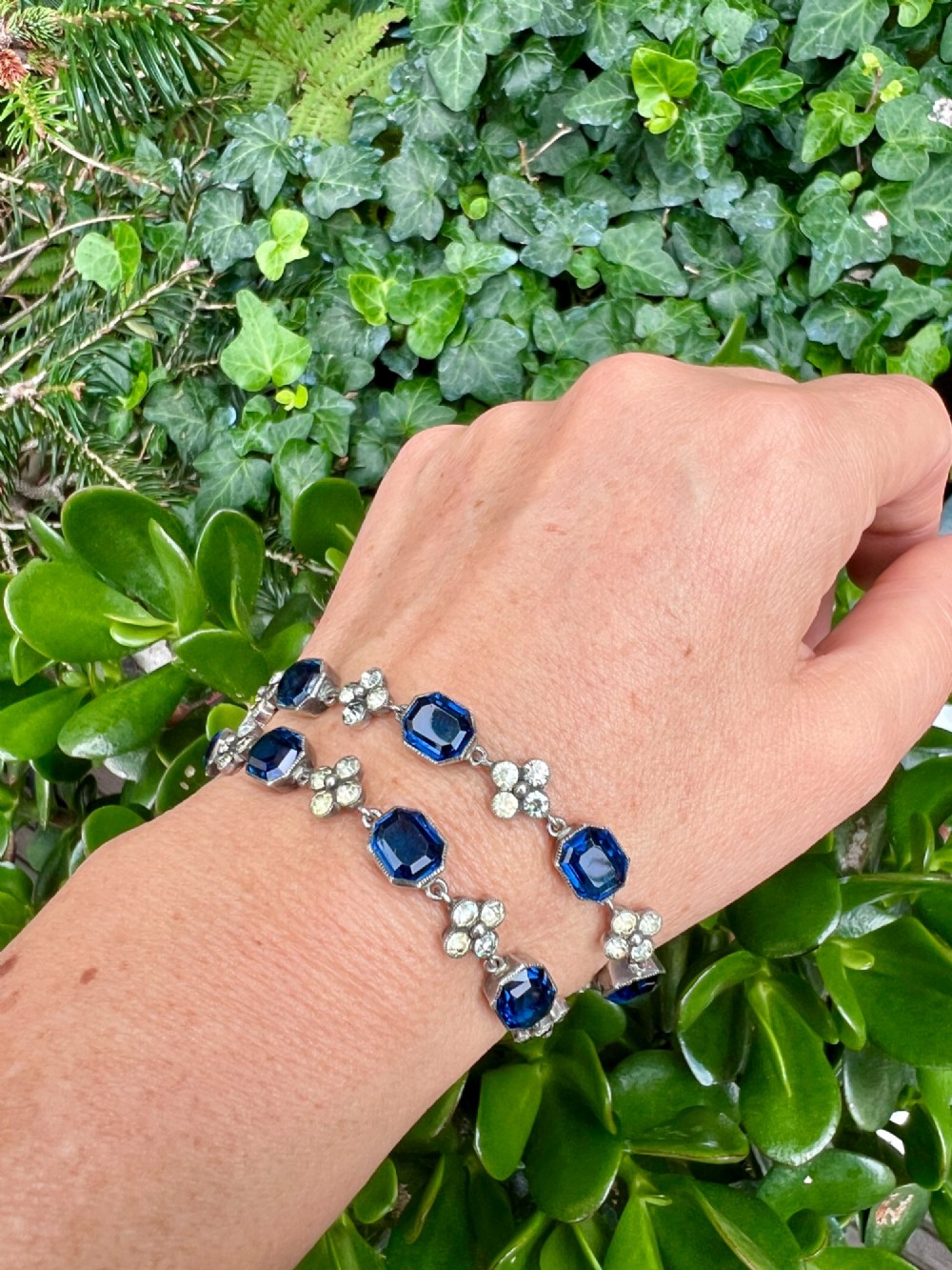 An Art Deco silver jewellery set comprising a link necklace and drop earrings with octagonal blue paste stones and clear cluster links. View X