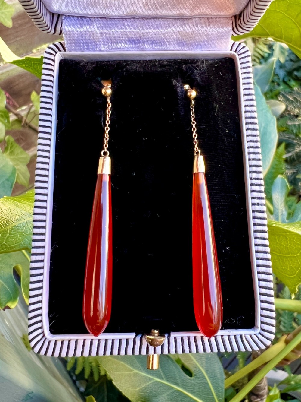 A pair of antique Edwardian drop earrings featuring long, polished teardrop-shaped carnelian stones suspended from delicate 9ct gold chains. View VII