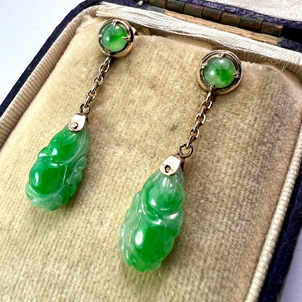 A pair of Art Deco 14ct gold drop earrings featuring circular green jade cabochons at the top connected by short chain links to teardrop-shaped carved green jade pendants. View VII