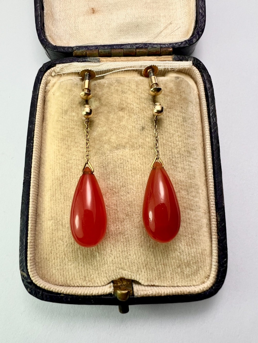 Pair of Edwardian 9ct gold screw-back earrings featuring delicate chains suspending polished teardrop-shaped red agate drops. View VI