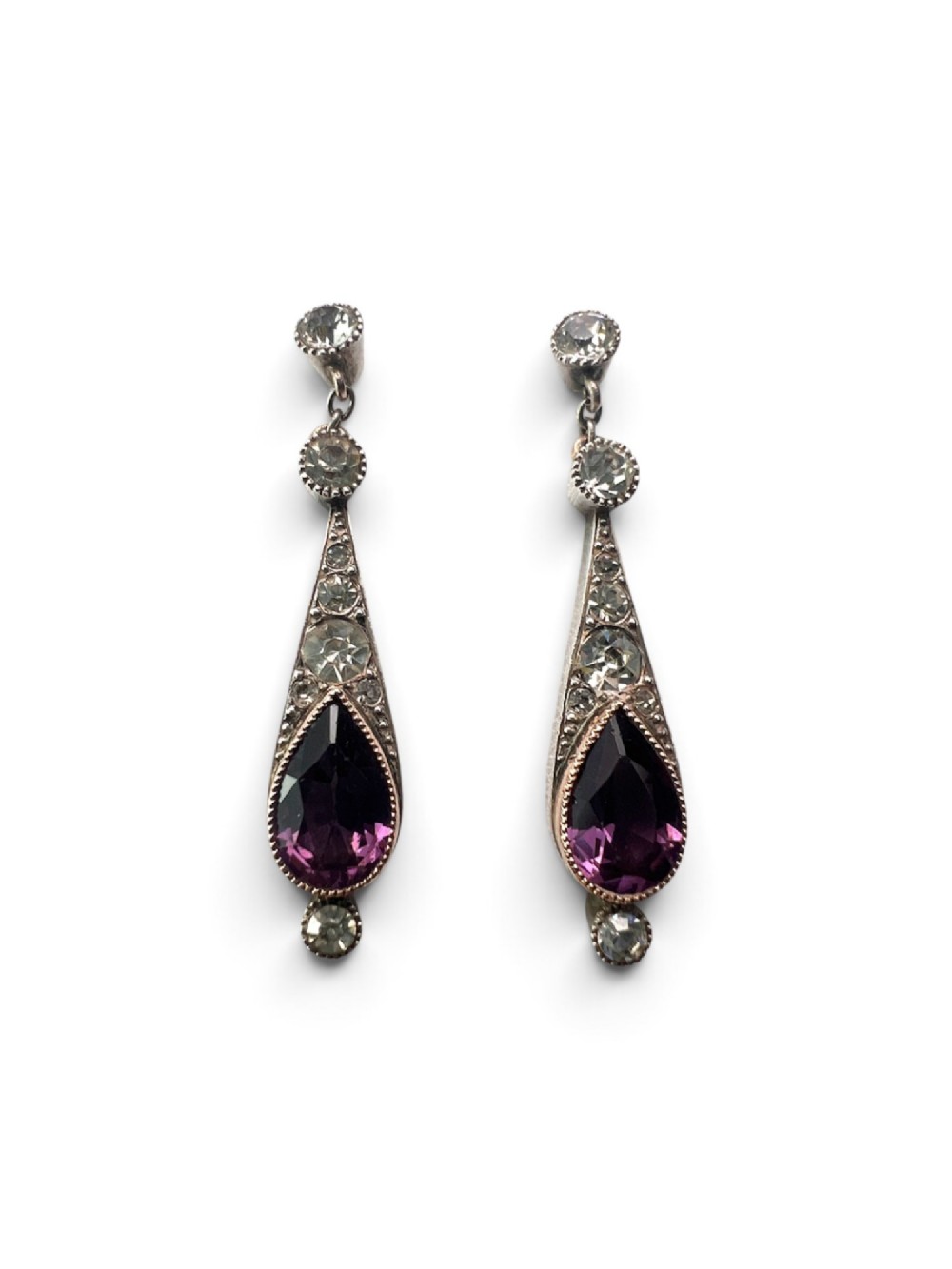 An Art Deco jewellery set featuring a silver chain necklace with teardrop purple paste drops and matching drop earrings. View V