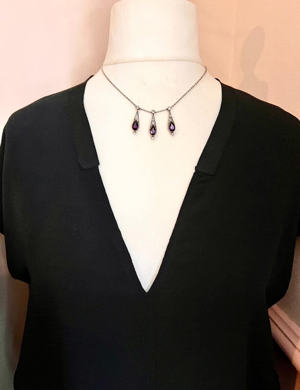 An Art Deco jewellery set featuring a silver chain necklace with teardrop purple paste drops and matching drop earrings. View VIII