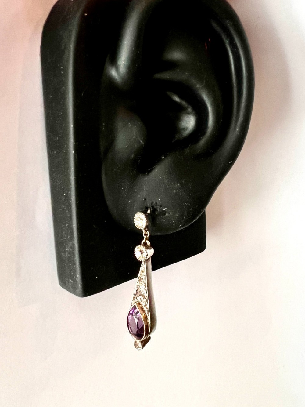 An Art Deco jewellery set featuring a silver chain necklace with teardrop purple paste drops and matching drop earrings. View IX