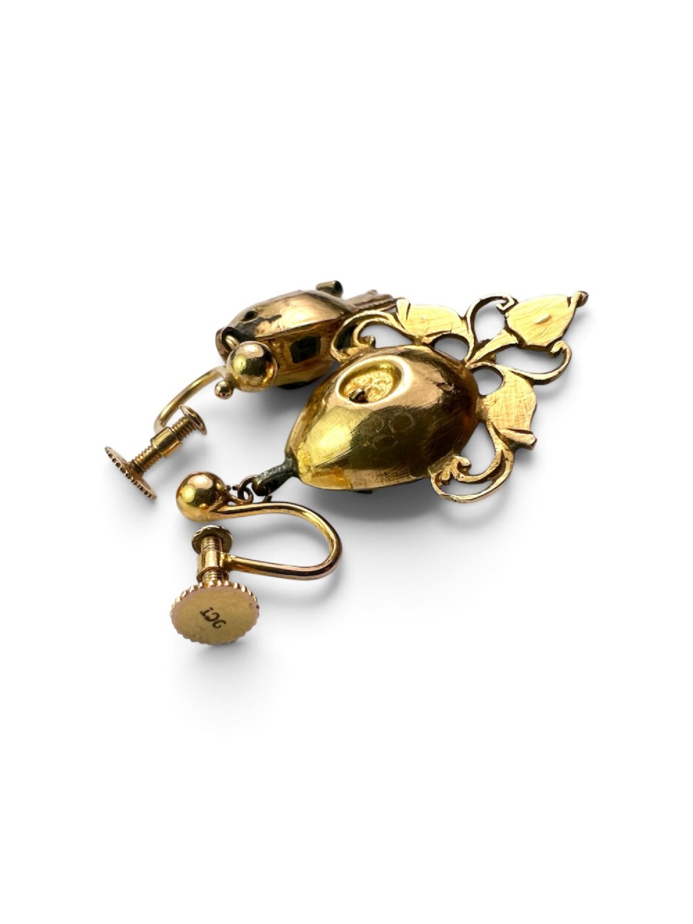 A pair of ornate Georgian yellow gold drop earrings featuring central step-cut green gemstones surrounded by smaller accent stones and scrollwork flourishes. View V