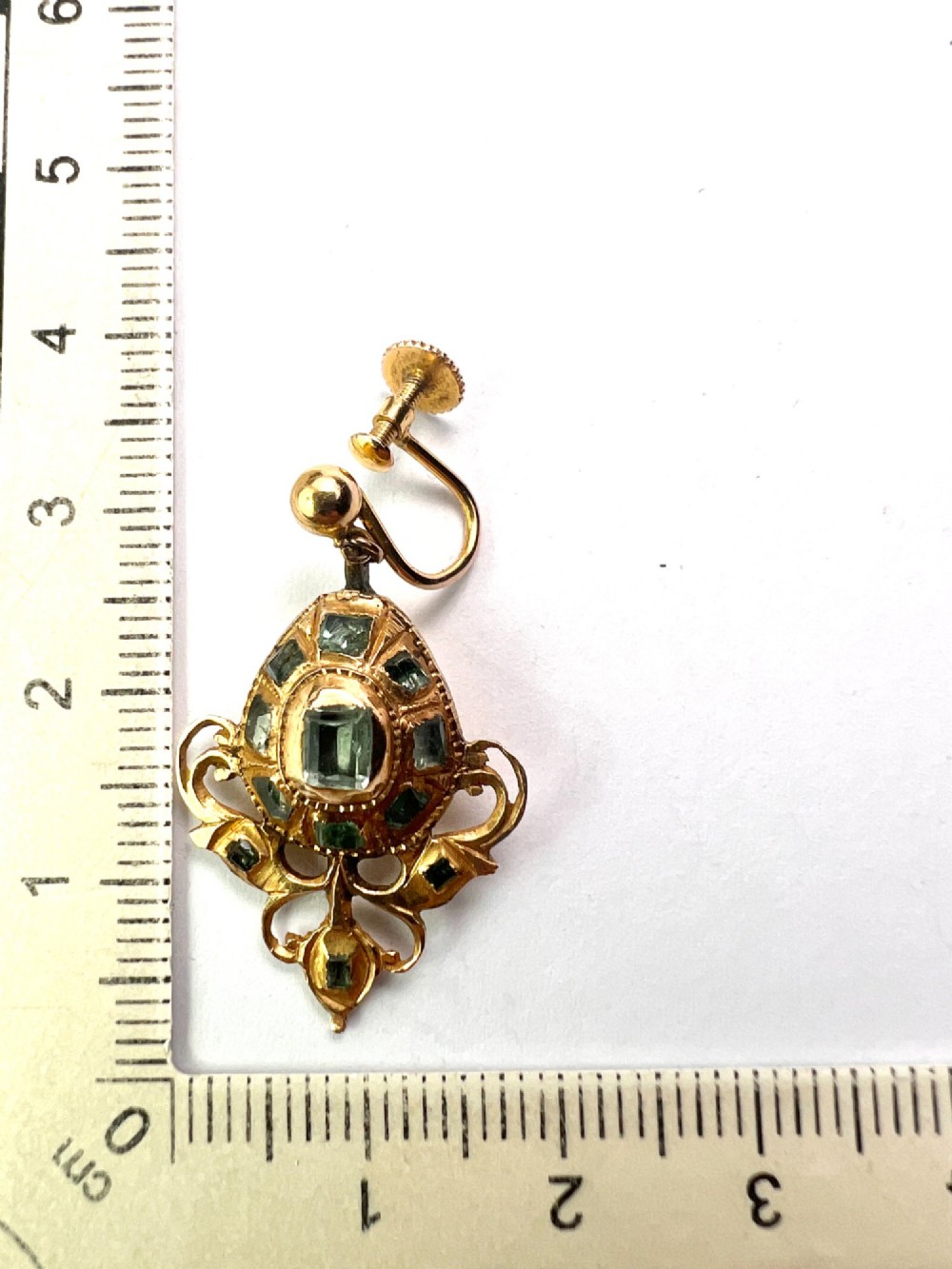 A pair of ornate Georgian yellow gold drop earrings featuring central step-cut green gemstones surrounded by smaller accent stones and scrollwork flourishes. View VIII