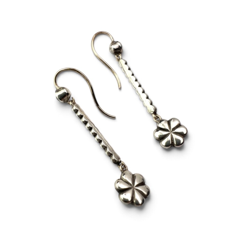 A pair of antique drop earrings featuring a linear row of round faceted paste stones terminating in a flower cluster drop. View IV
