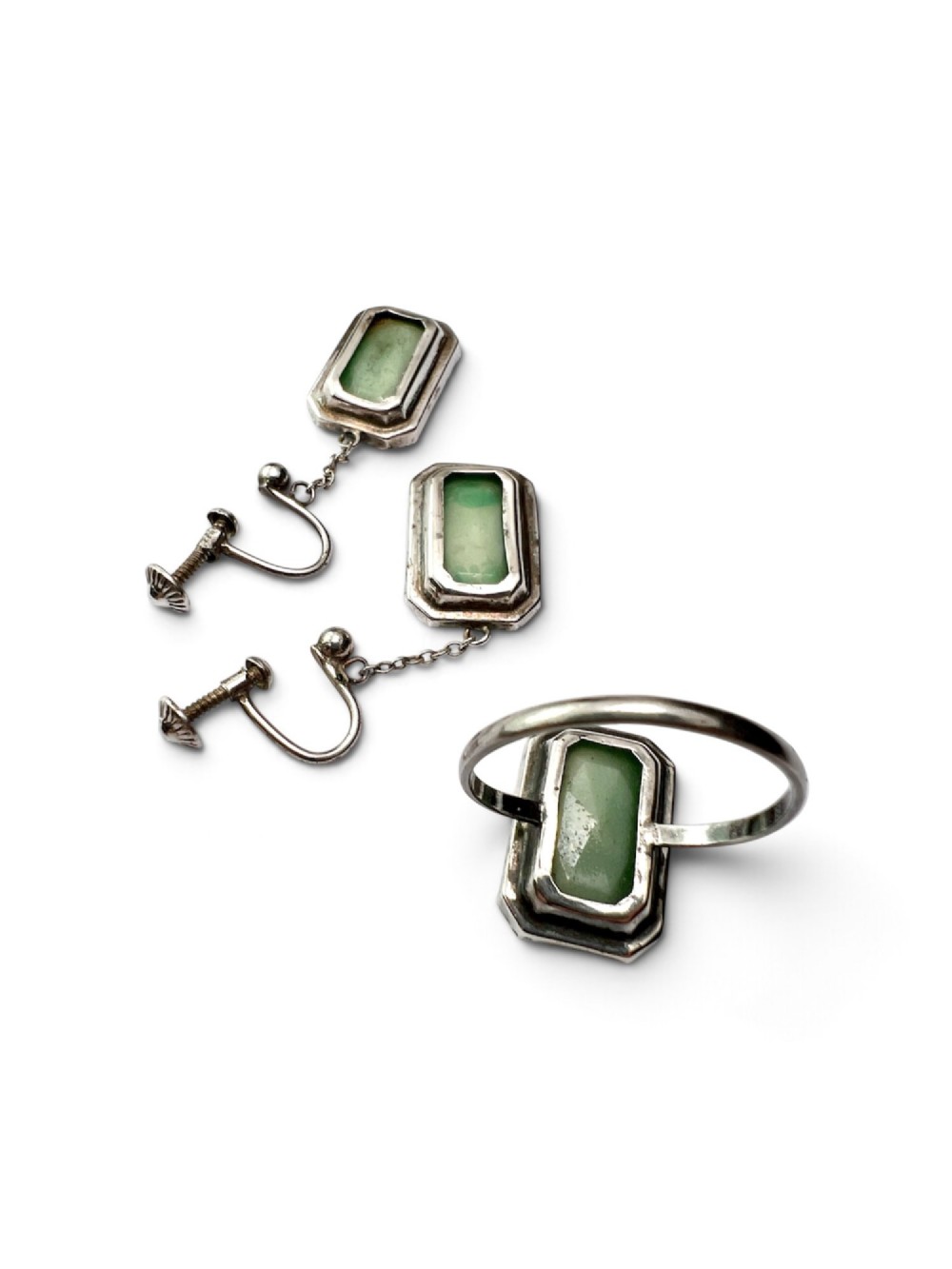 An Art Deco silver jewellery set featuring a rectangular ring and matching drop earrings inset with green glass plaques and clear step-cut paste stones. View VI