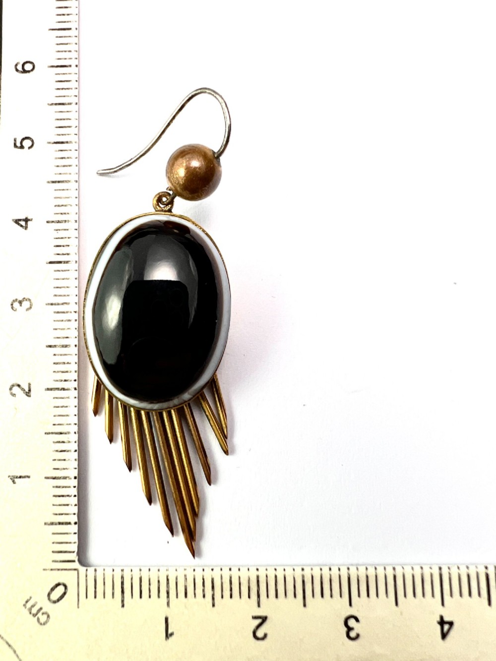 A pair of Victorian drop earrings featuring oval bullseye agate cabochons set in gold frames with graduating metallic fringe spikes below. View VII