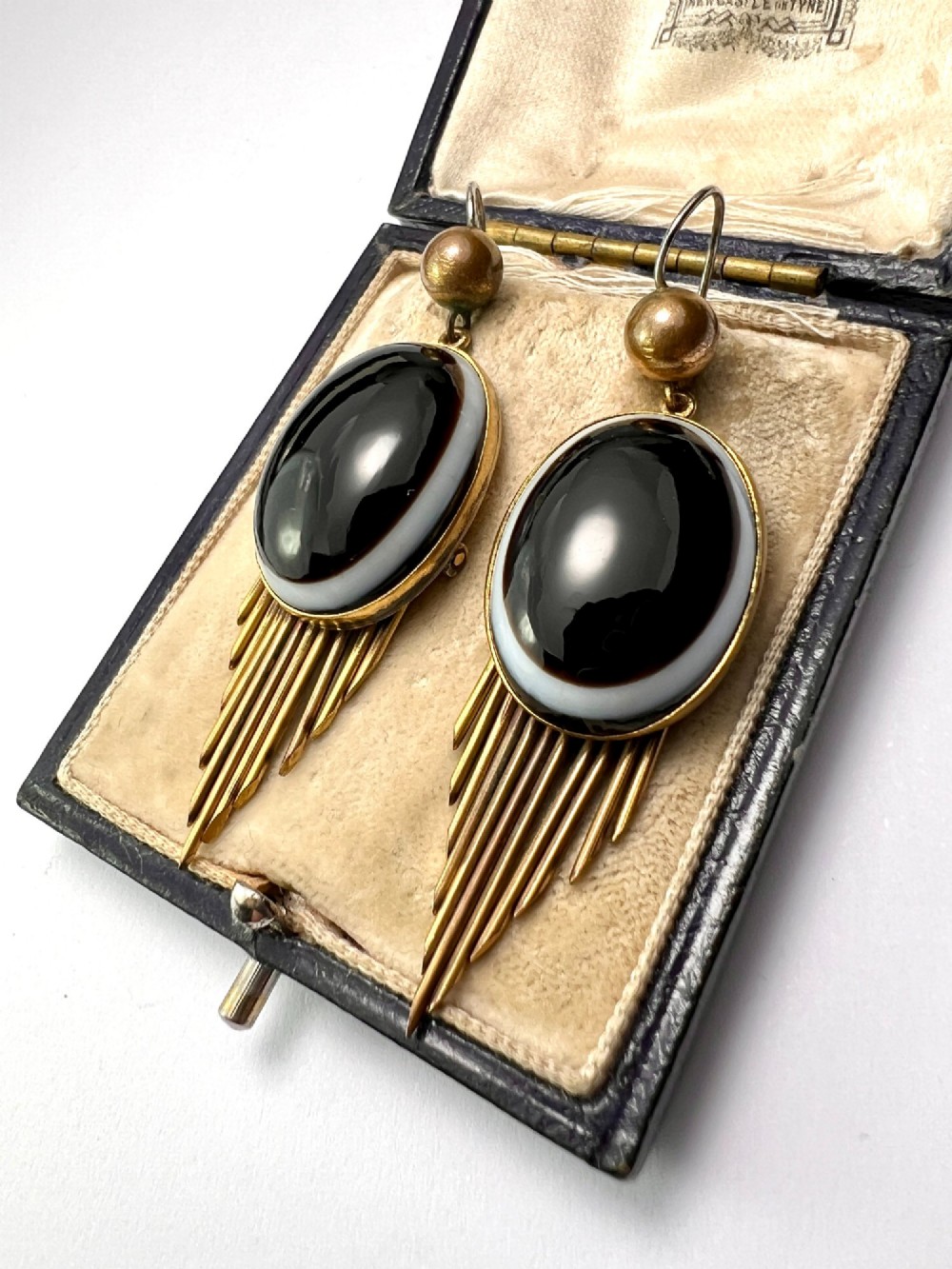A pair of Victorian drop earrings featuring oval bullseye agate cabochons set in gold frames with graduating metallic fringe spikes below. View VIII