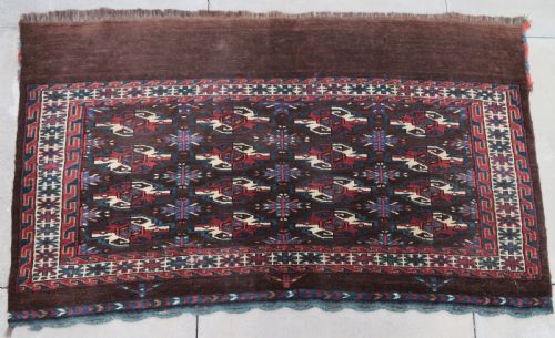 fig 1. A rectangular hand-woven Yomut Turkmen wool chuval bag face featuring sixteen repeating central guls framed by geometric borders and a solid dark brown lower elem skirt.