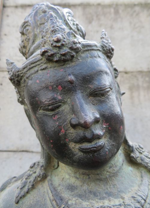 fig 2. A dark bronze sculpture of a seated Bodhisattva Avalokitesvara featuring an ornate crown, beaded jewellery, and a double lotus pedestal base.