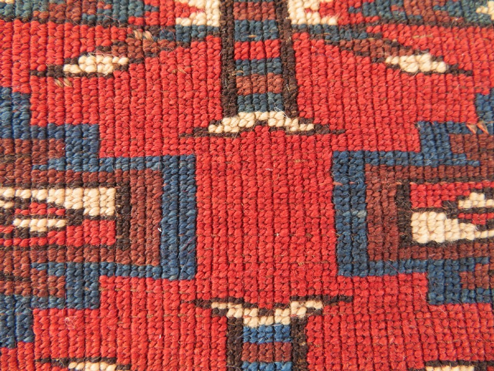 A rectangular hand-knotted Yomut Turkmen chuval rug featuring repeating gul motifs on a deep red field with a geometric border and diamond-patterned lower elem. View XX