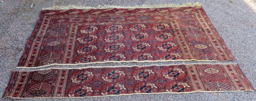 An antique Tekke Turkmen main carpet and matching runner featuring traditional repeating gul motifs in deep red, navy blue, and ivory hand-woven wool.