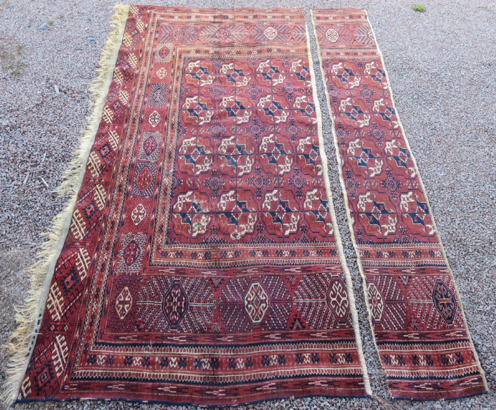 An antique Tekke Turkmen main carpet and matching runner featuring traditional repeating gul motifs in deep red, navy blue, and ivory hand-woven wool. View II