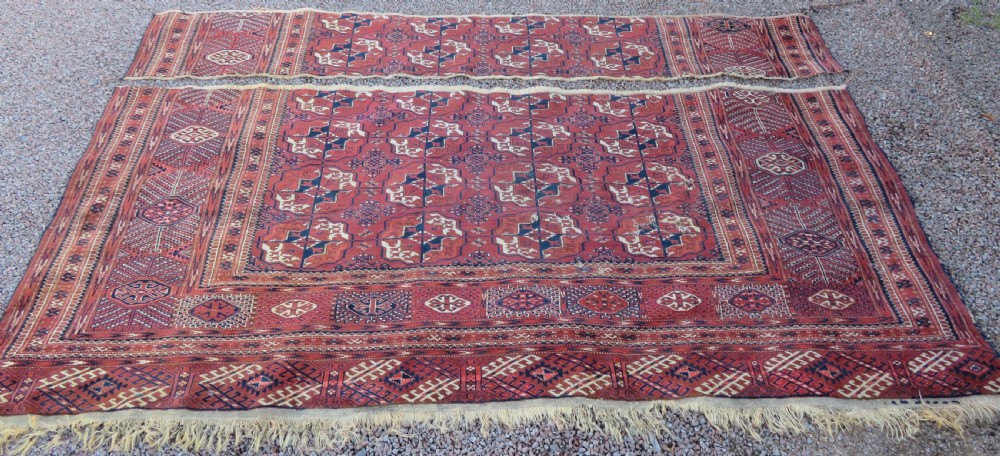 An antique Tekke Turkmen main carpet and matching runner featuring traditional repeating gul motifs in deep red, navy blue, and ivory hand-woven wool. View III