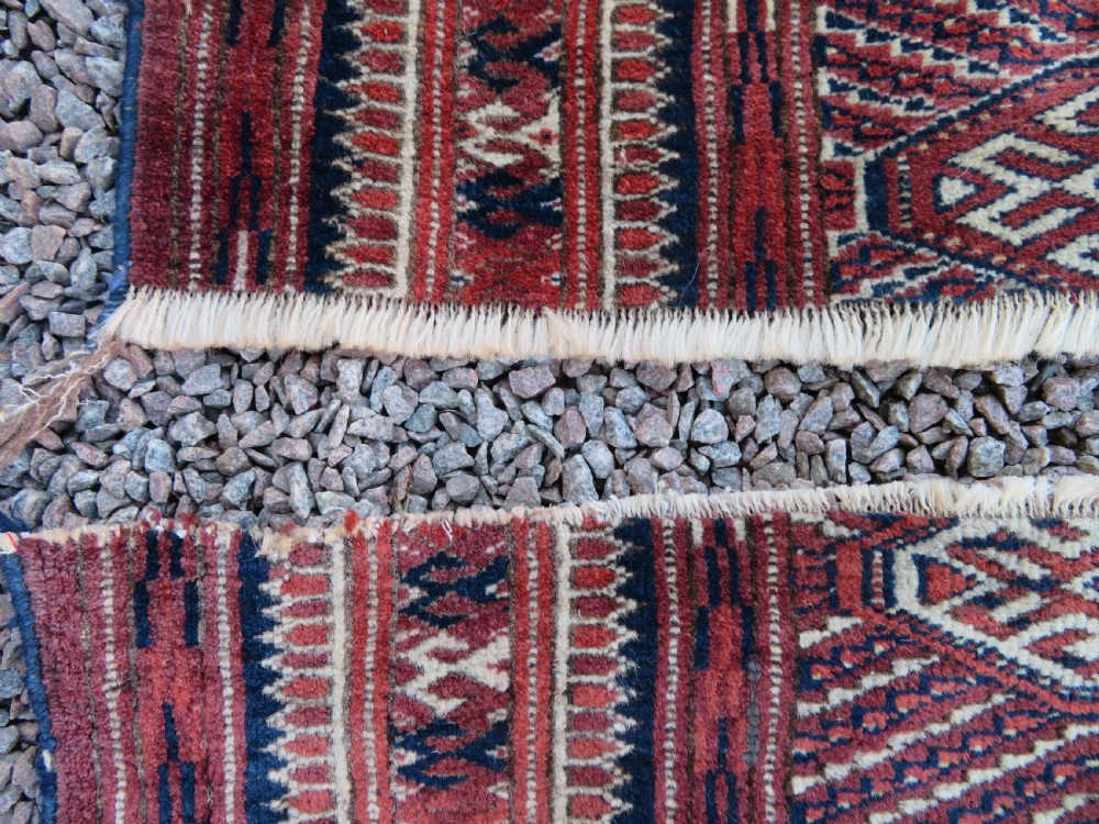 An antique Tekke Turkmen main carpet and matching runner featuring traditional repeating gul motifs in deep red, navy blue, and ivory hand-woven wool. View VI