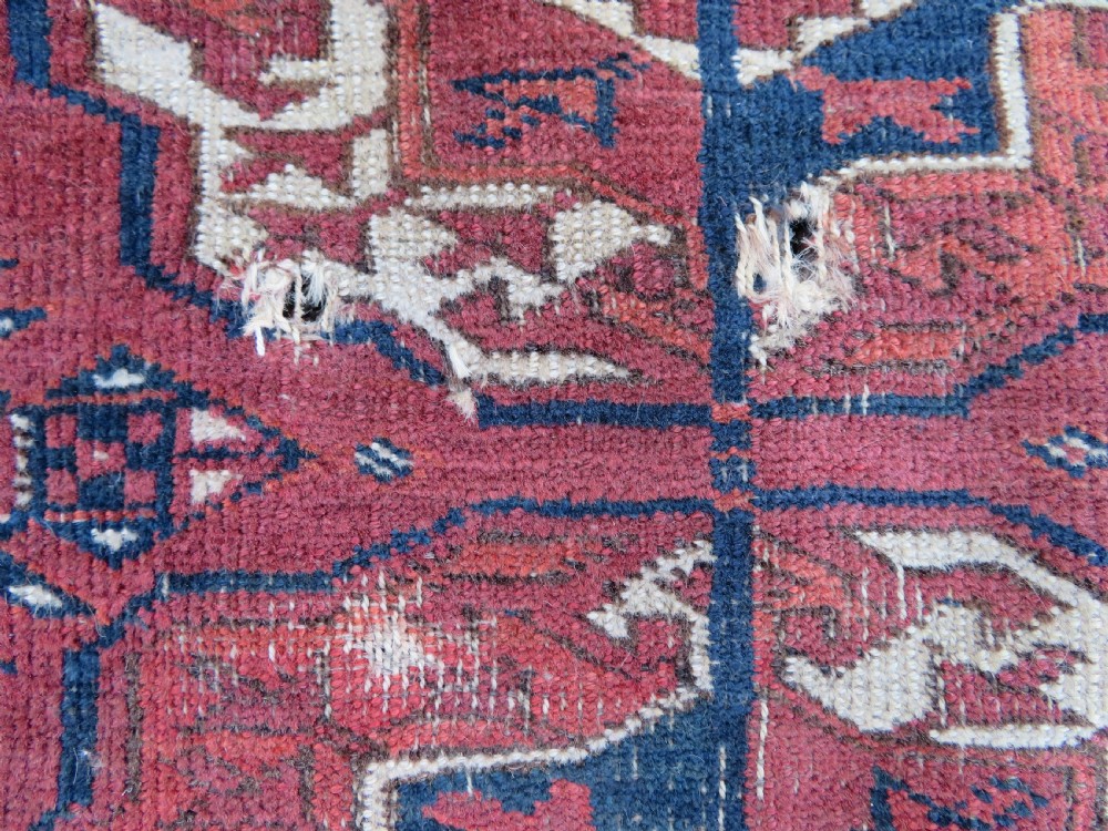 An antique Tekke Turkmen main carpet and matching runner featuring traditional repeating gul motifs in deep red, navy blue, and ivory hand-woven wool. View X