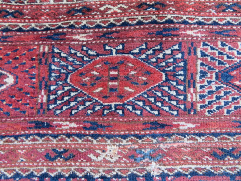 An antique Tekke Turkmen main carpet and matching runner featuring traditional repeating gul motifs in deep red, navy blue, and ivory hand-woven wool. View XI