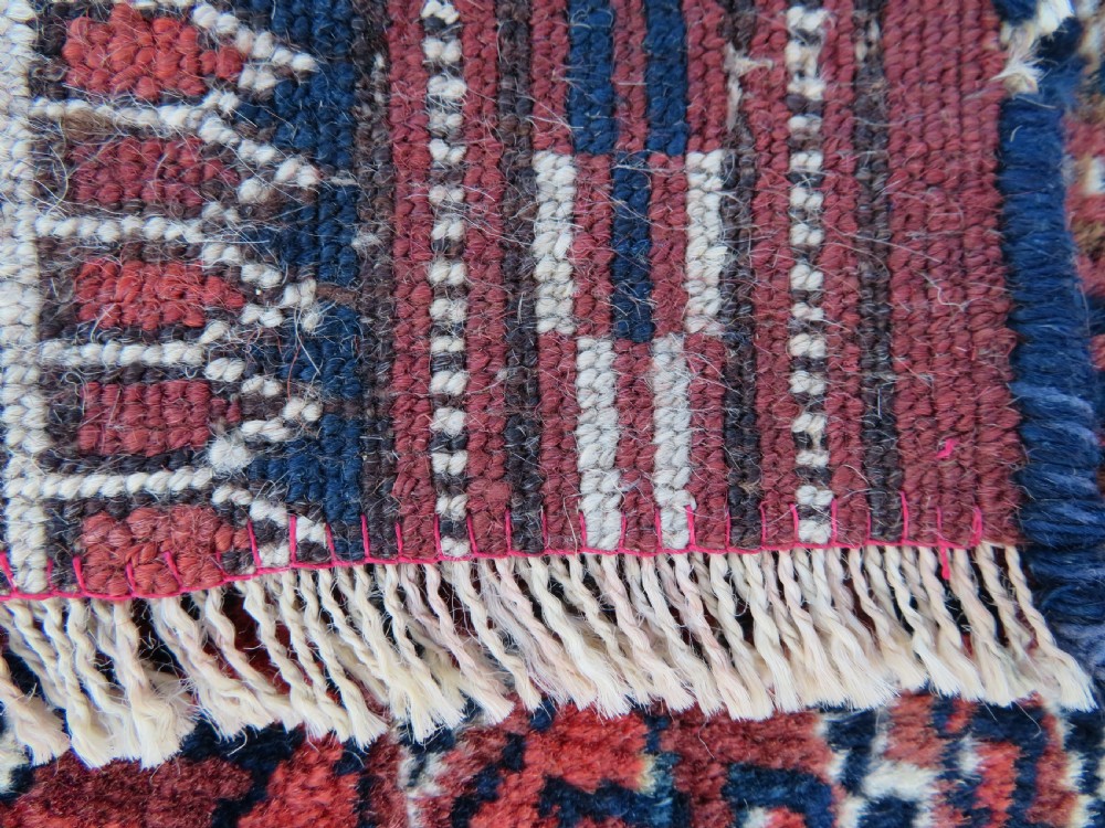 An antique Tekke Turkmen main carpet and matching runner featuring traditional repeating gul motifs in deep red, navy blue, and ivory hand-woven wool. View XIV