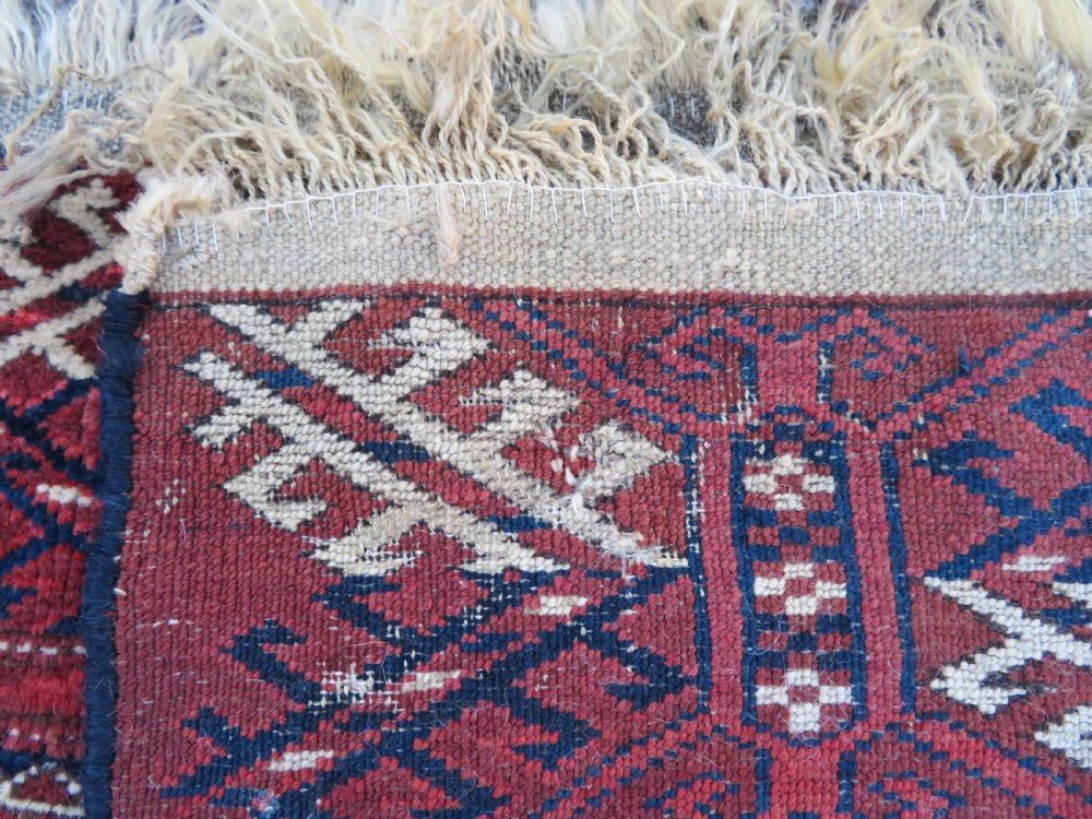 An antique Tekke Turkmen main carpet and matching runner featuring traditional repeating gul motifs in deep red, navy blue, and ivory hand-woven wool. View XV